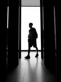 Full length of silhouette woman standing at entrance of building