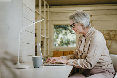 Businesswoman using laptop at desk in office