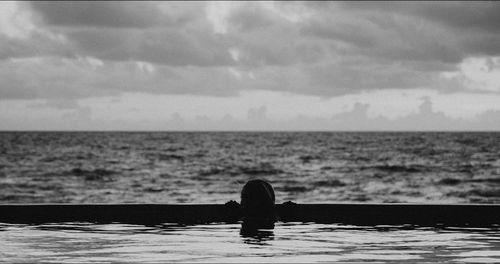 Silhouette person against sea against sky