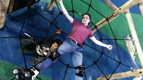 Portrait of happy girl playing on slide at playground