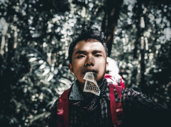 A man in the middle of the forest drinks honey in the form of a sachet to increase his immune system