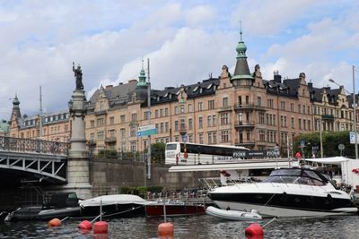 Boats moored on river against buildings in city
