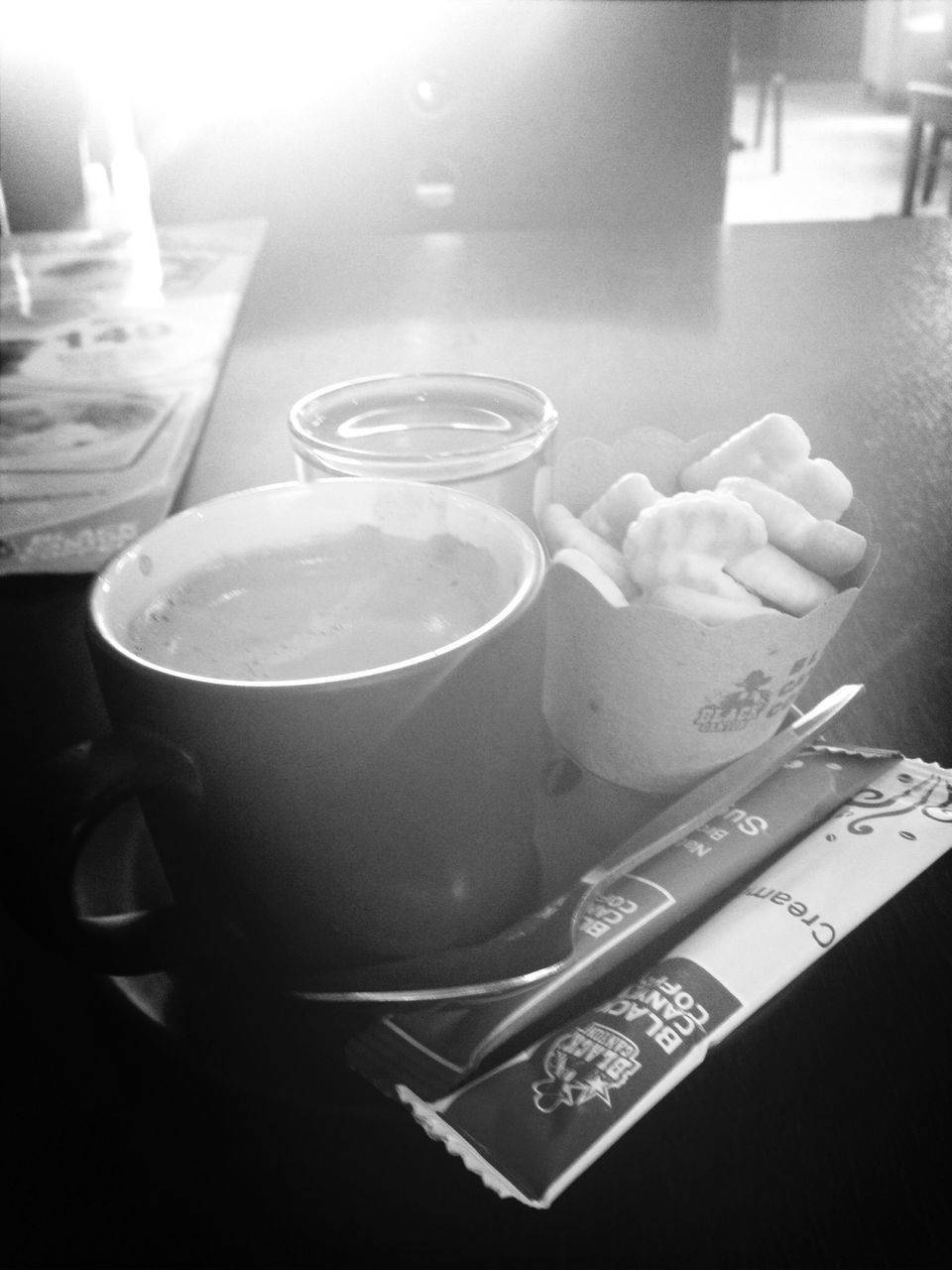 indoors, table, still life, food and drink, drink, close-up, refreshment, plate, no people, coffee cup, high angle view, freshness, home interior, cup, drinking glass, paper, fork, book, spoon, saucer