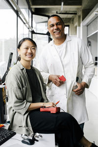 Portrait of happy multiracial male and female technicians at repair shop