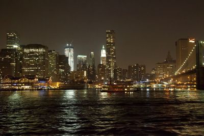 Illuminated buildings in city against sky at night