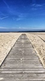 Pier on beach against sky