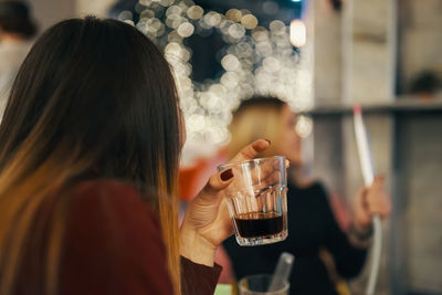 Rear view of woman drinking glass