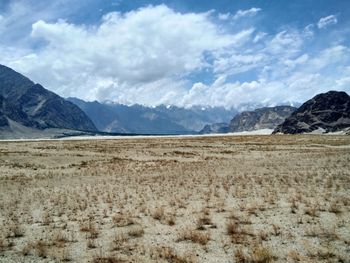 Scenic view of mountains against cloudy sky