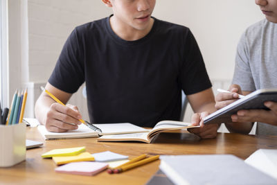 Young students campus helps friend catching up and learning.