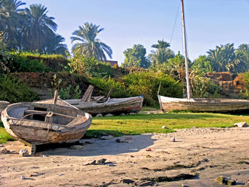 Boats moored on beach against clear sky