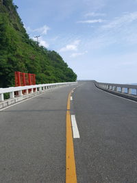 Surface level of road by bridge against sky