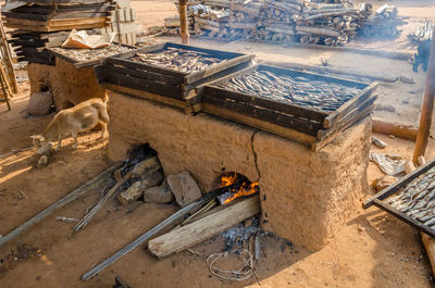 High angle view of preparation of smoked fish on clay oven outdoors, ghana, africa