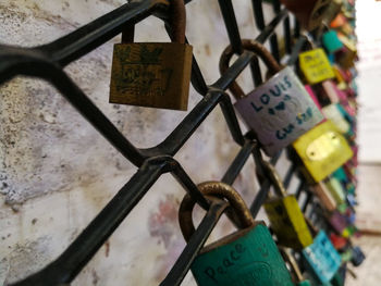 Close-up of padlocks hanging on railing by river