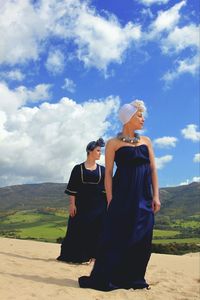 Friends standing on land against sky