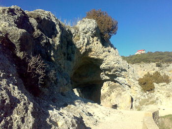 Low angle view of rock formation against clear blue sky