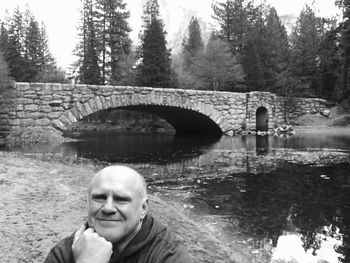 Portrait of man on bridge over river