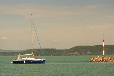 Sailboat sailing on sea against sky