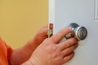 Cropped hands holding doorknob