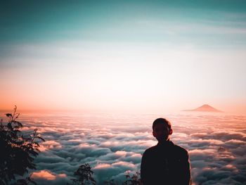 Rear view of silhouette man standing against sky during sunset