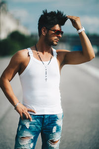 Young man looking away while standing outdoors