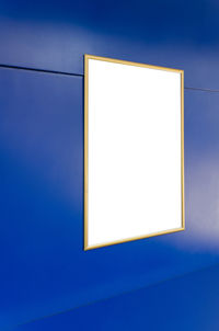 Close-up of illuminated lamp against blue sky