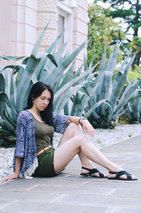 Portrait of young happy brunette asian woman relaxing in city, park. summer vacation. travel