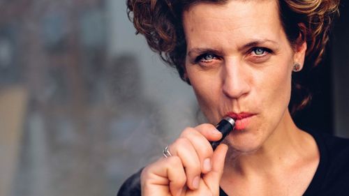 Close-up portrait of woman smoking cigarette