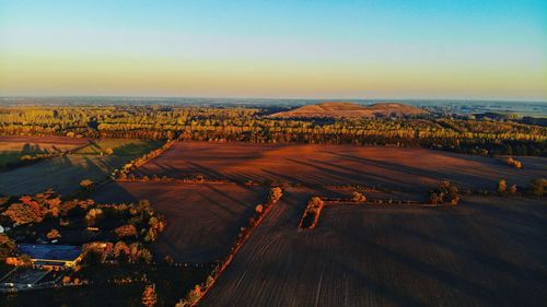 High angle view of road amidst field against clear sky