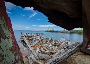 Abandoned boats on beach against sky