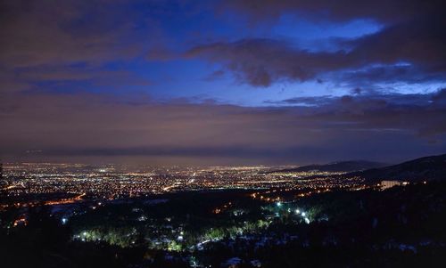 High angle view of illuminated cityscape against sky at night