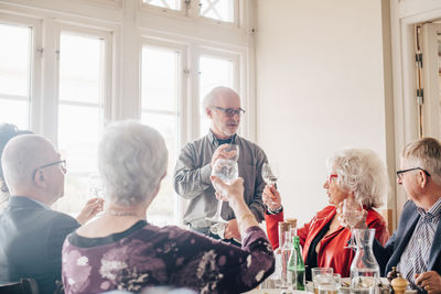 Senior friends with wineglass toasting in restaurant