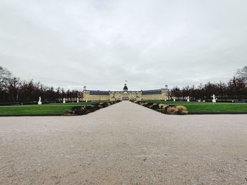 View of footpath against cloudy sky