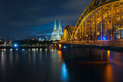 Bridge over river in city at night