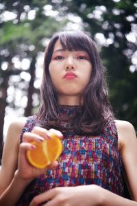 Portrait of woman holding orange