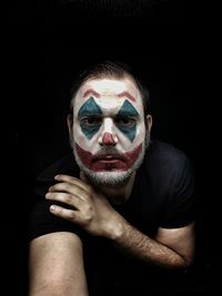 Portrait of man wearing mask against black background