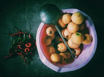 Directly above shot of apples and ladle in basket by chili pepper on table