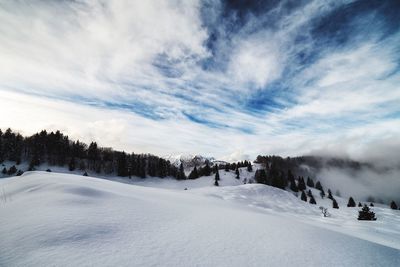 Scenic view of snowcapped mountains against cloudy sky