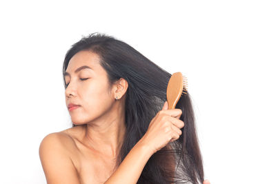 Portrait of woman making face against white background