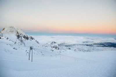 Scenic view of snow covered mountains against sky during sunset