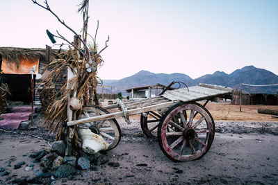 Damaged bicycle on field against sky