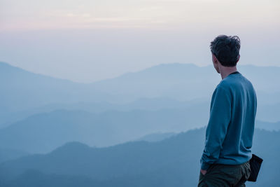 Hiker man relax with wellbeing and happy feeling on top of mountain