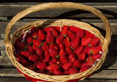 High angle view of fresh strawberry fruits in wicker basket on table