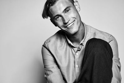 Portrait of young man standing against white background