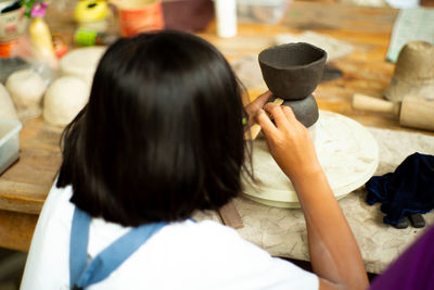 Rear view of woman sitting with arms raised