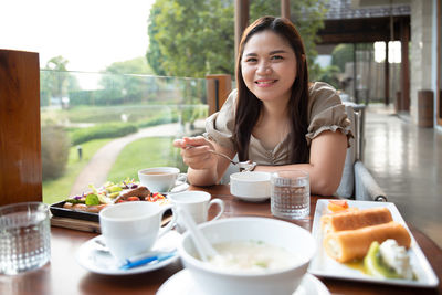 Portrait of young woman sitting with food