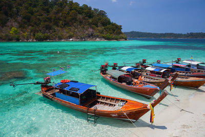 Boat moored on sea shore against sky