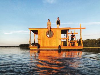 Man and women sitting on boat against sky