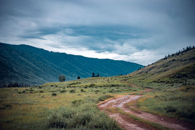 Scenic view of a country road, mountain landscape against sky, altai, russia