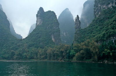 Scenic view of river and mountains against sky