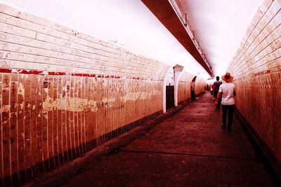 Rear view of people walking in subway